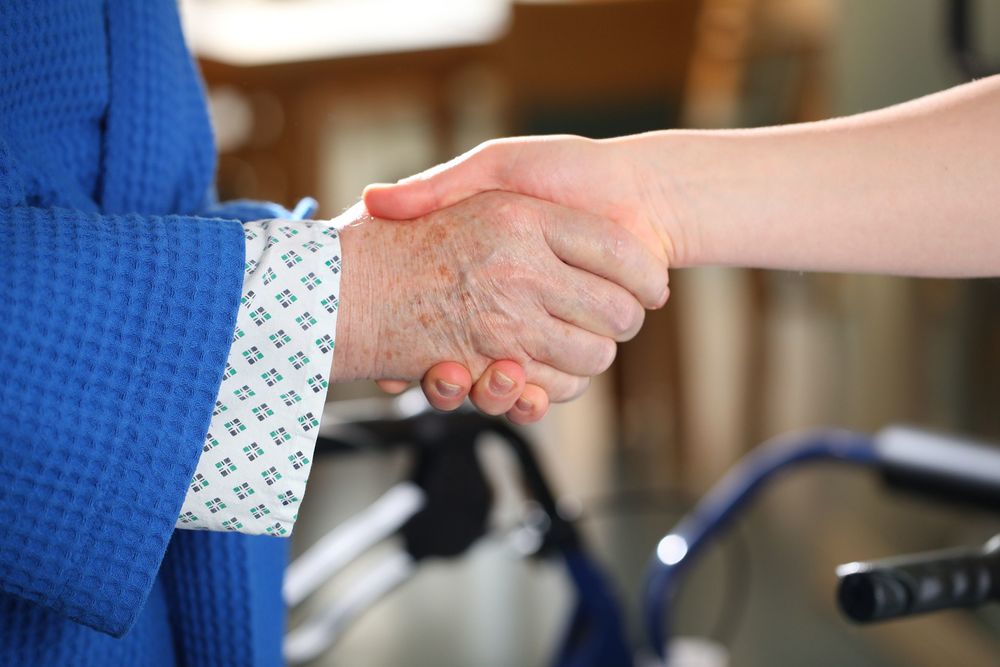 Patientin und Ärztin oder Pflegerin reichen sich die Hand / Barmherzige Brüder Papst Franziskus dankt allen, die sich um Kranke kümmern