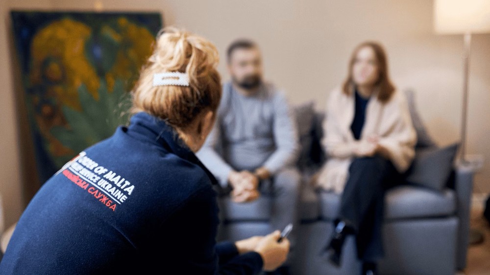 Familie im Gespräch mit Mitarbeiterin aus Psychosozialem Dienst von Malteser Ukraine / Malteser Ukraine / Malteser International Malteser-Helfer in Ukraine: 'Auch jedes Kind ist vom Krieg betroffen'